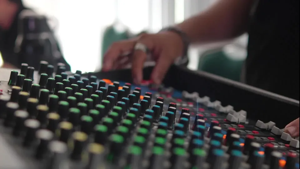 Production crew operating an audio mixing console at an event